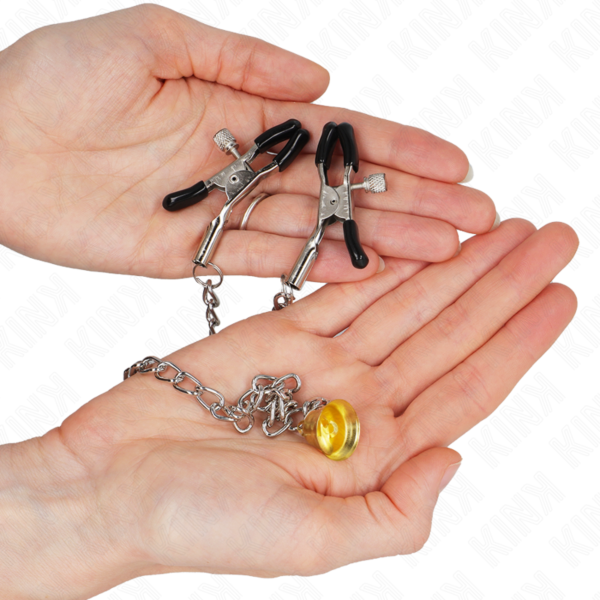 Dvě svorky na bradavky Kink Nipple Grip spojené řetízkem se zlatou rolničkou